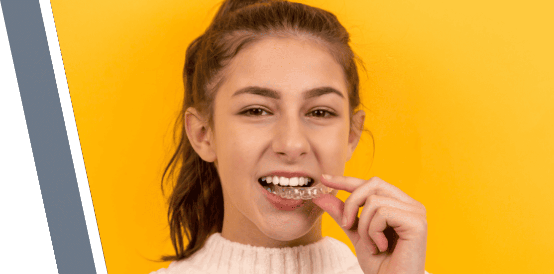 Teen wearing clear aligners and smiling.