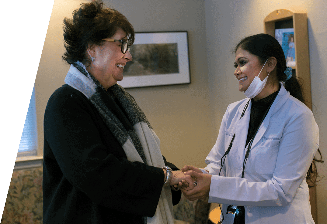 Dr. Purvi Patel greeting a elderly woman patient with a handshake.
